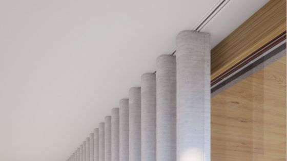 Close-up of a modern, recessed curtain track system installed in a ceiling, featuring neatly arranged wave curtains hanging in soft, uniform folds. The sleek, minimal design showcases the curtain track seamlessly integrated into the ceiling, creating a cl